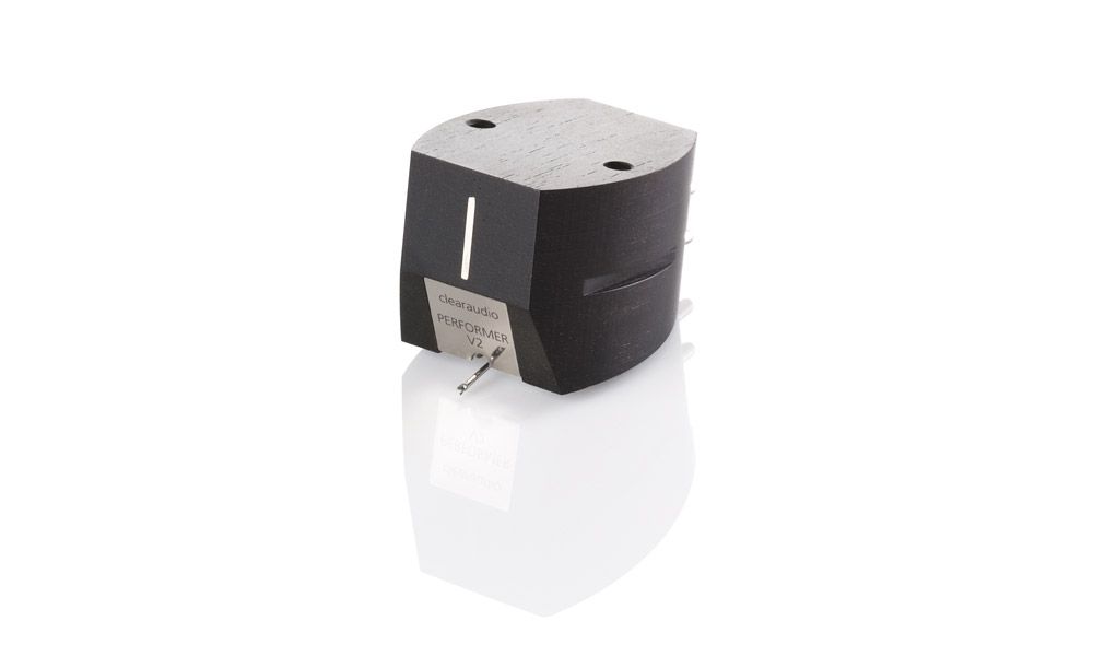 Produktfoto des clearaudio „Performer V2“ Tonabnehmers für Plattenspieler vor rein weißem Hintergrund. Das mattschwarze Gehäuse aus Ebenholz zeigt eine feine, natürliche Holzmaserung und spiegelt sich leicht nach unten hin. An der Vorderseite befindet sich ein silbernes Metallplättchen mit der Gravur „clearaudio PERFORMER V2“ sowie der nach unten ragende Nadelträger.