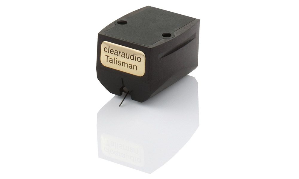 Produktfoto des clearaudio „Talisman“ Tonabnehmers vor weißem Hintergrund. Das Gehäuse ist mattschwarz und spiegelt sich leicht nach unten hin. An der Vorderseite ist ein markantes, goldenes Metallplättchen mit abgerundeten Ecken angebracht, auf dem der Schriftzug „clearaudio Talisman“ eingraviert ist. Der filigrane Nadelträger ragt unten aus dem System.
