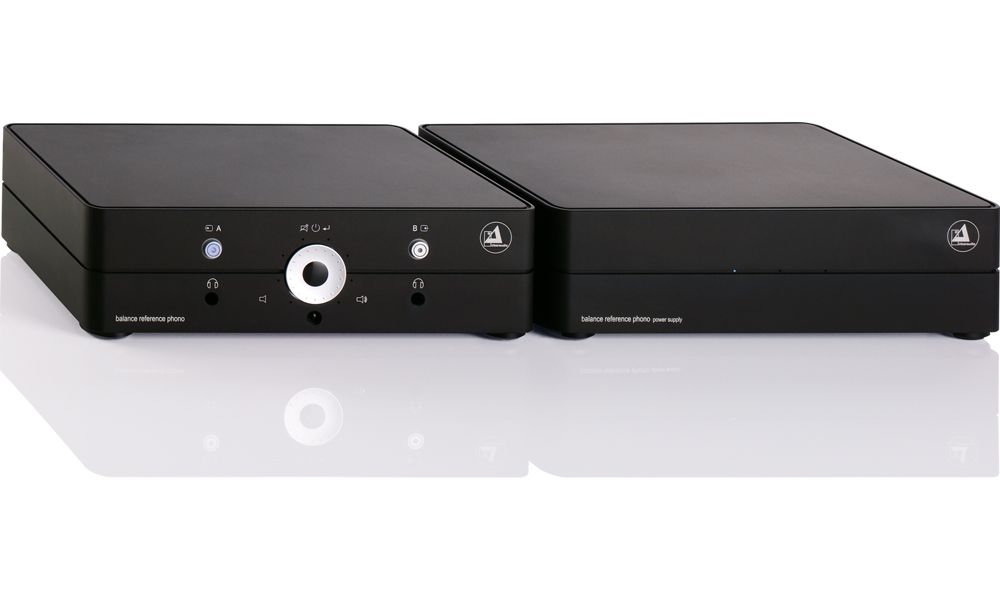 Zwei edle, tiefschwarze Gehäusekomponenten des clearaudio Phonosystems (Phonovorstufe und separates Netzteil) aus massivem Aluminium, nebeneinander auf einer weißen, spiegelnden Oberfläche.