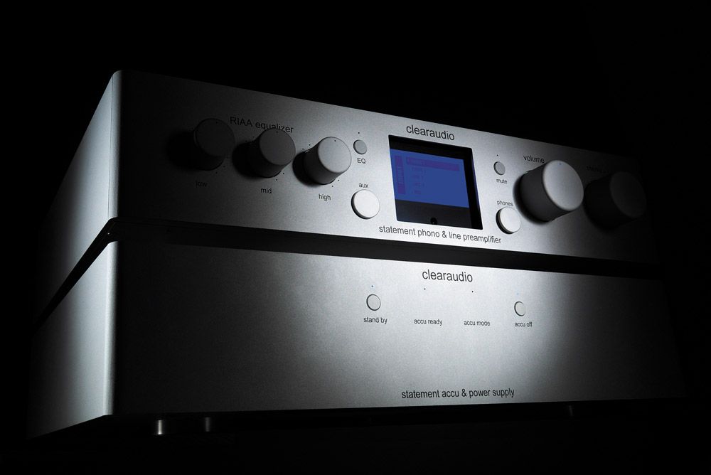 Zweiteiliges, silbernes clearaudio statement phono Audiosystem bestehend aus Vorverstärker und Akku-Netzteil, dramatisch inszeniert vor schwarzem Hintergrund.