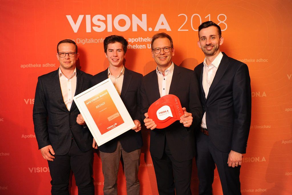 Ralf König mit Mitarbeiter bei der Entgegennahme des Vision A bronze Preises