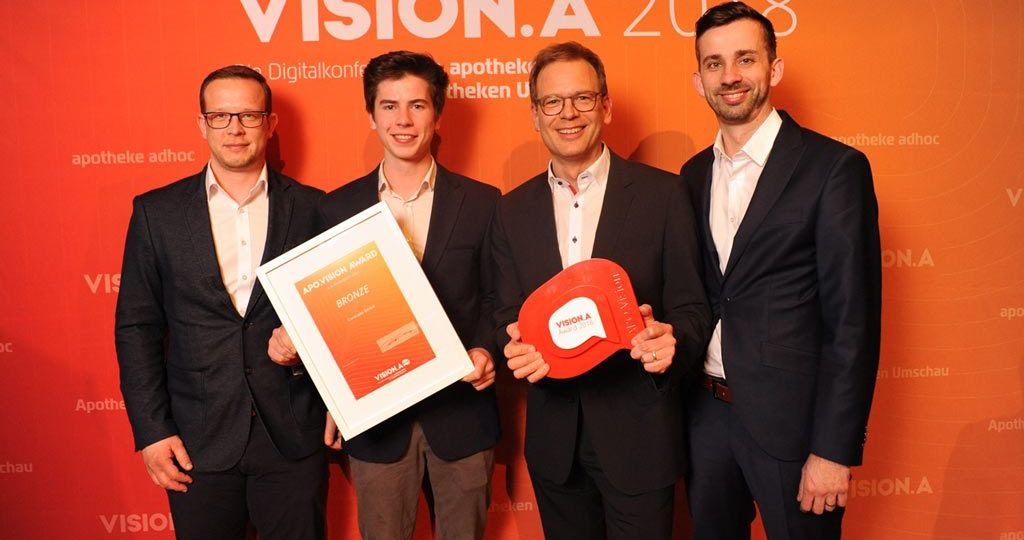 Ralf König mit Mitarbeiter bei der Entgegennahme des Vision A bronze Preises