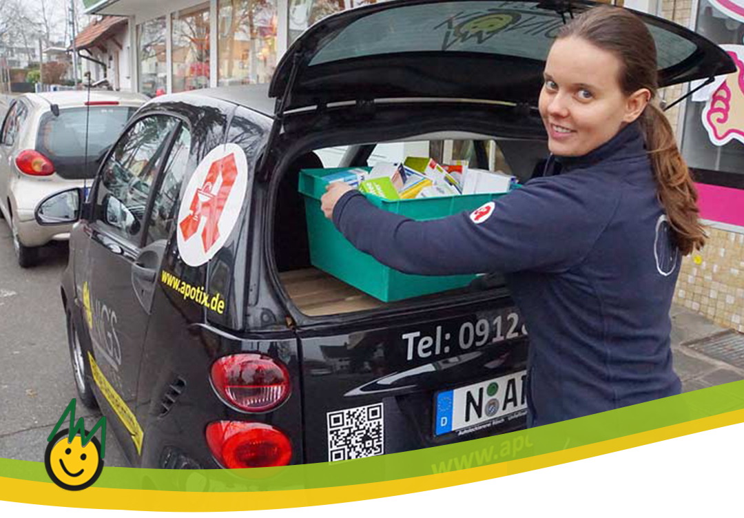 Mitarbeiterin lädt Arzneimittellieferung ins Auto