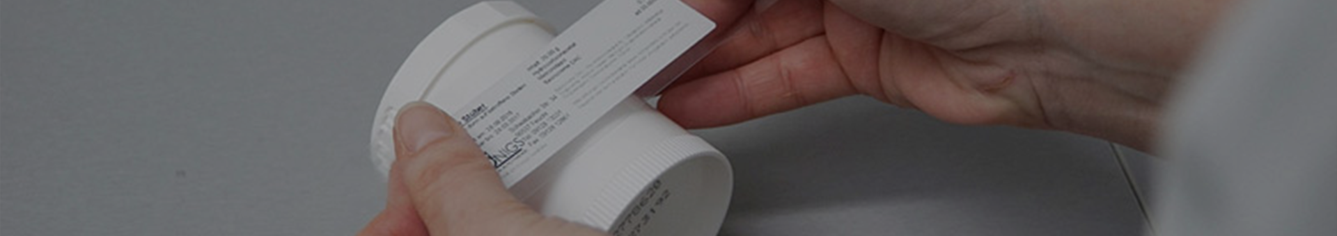 Hand klebt ein Etikett auf eine Kruke