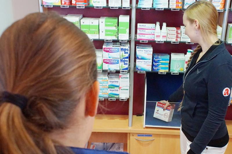 Mitarbeiterin holt Medikament aus dem Kommiauswurf