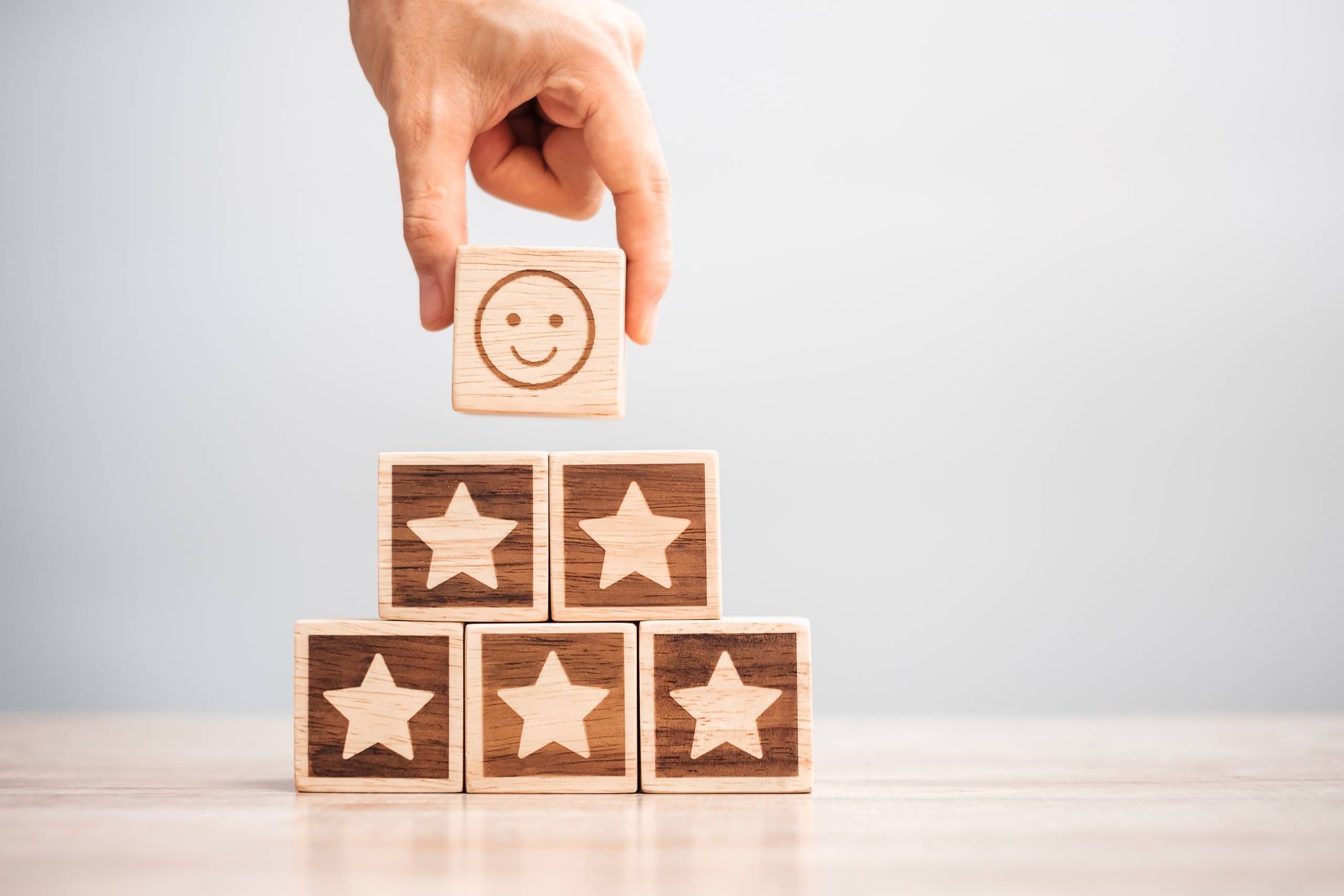 Hand hält SmileyWürfel über Würfeln mit Sternen