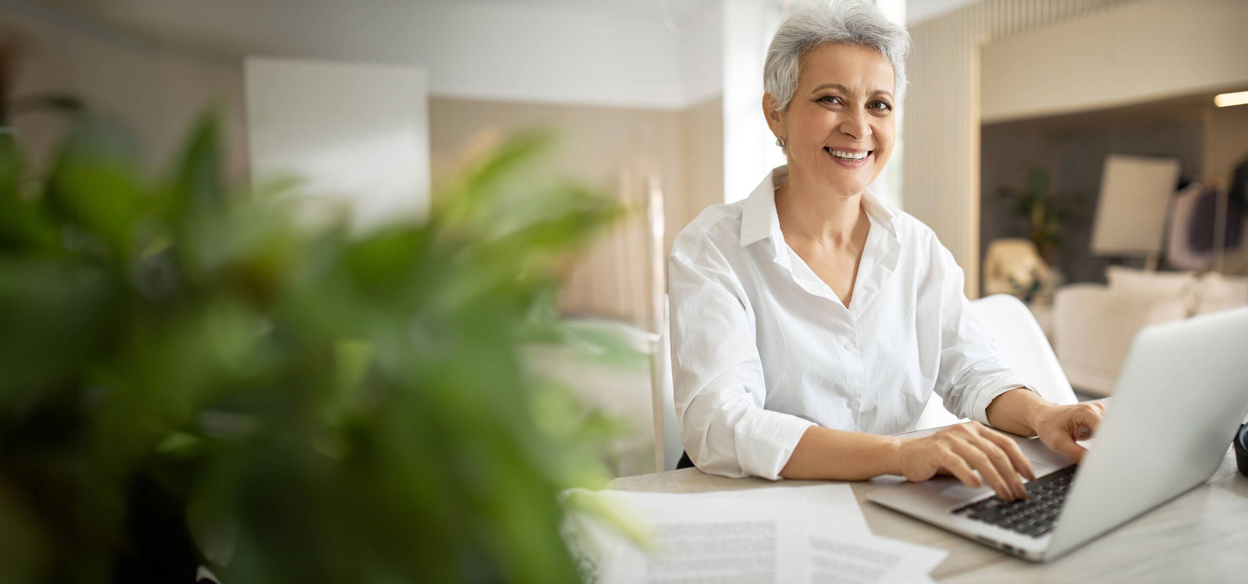 Ältere Frau sitzt am Laptop