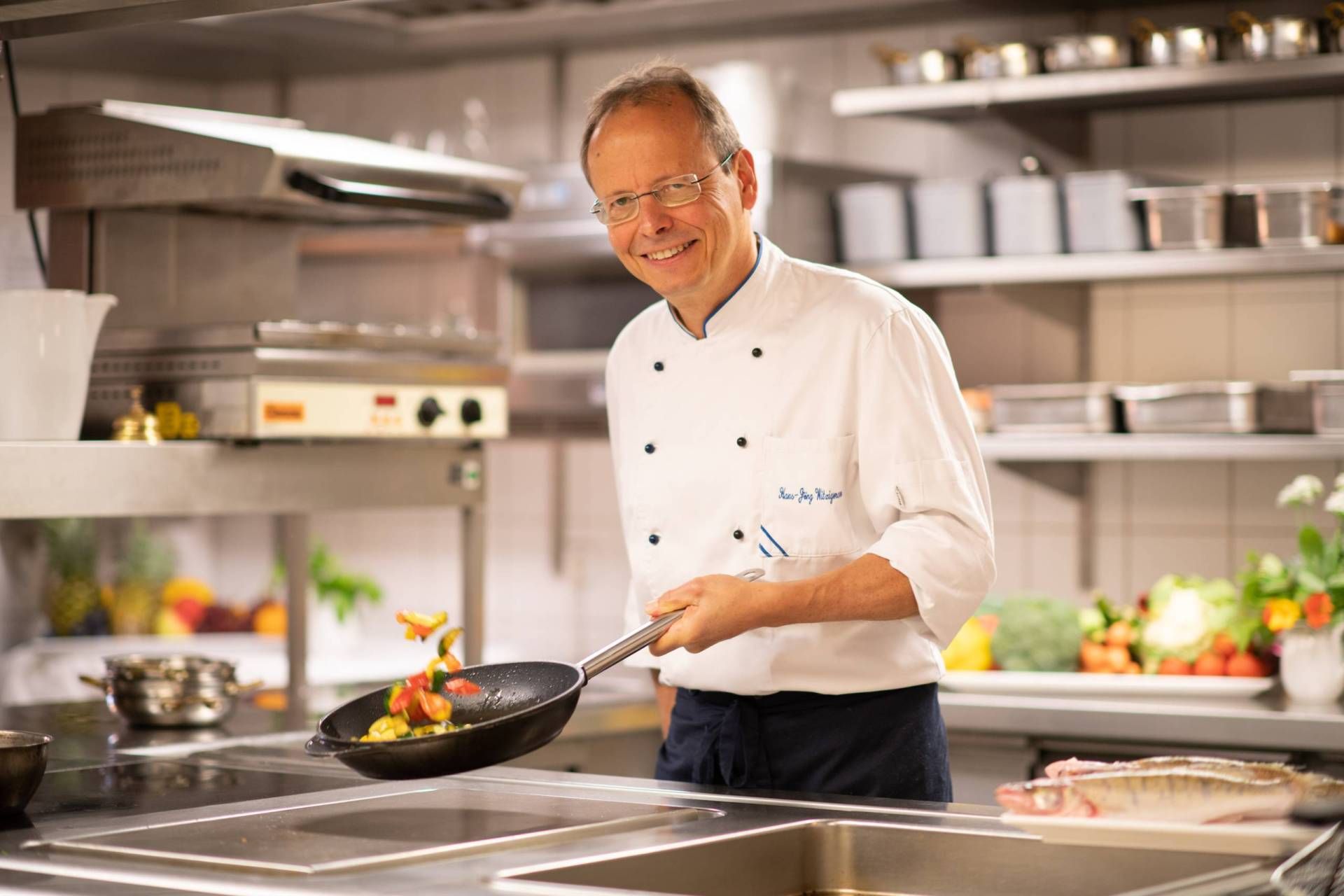 Koch in einer Gaststätte am Herd mit einer Pfanne