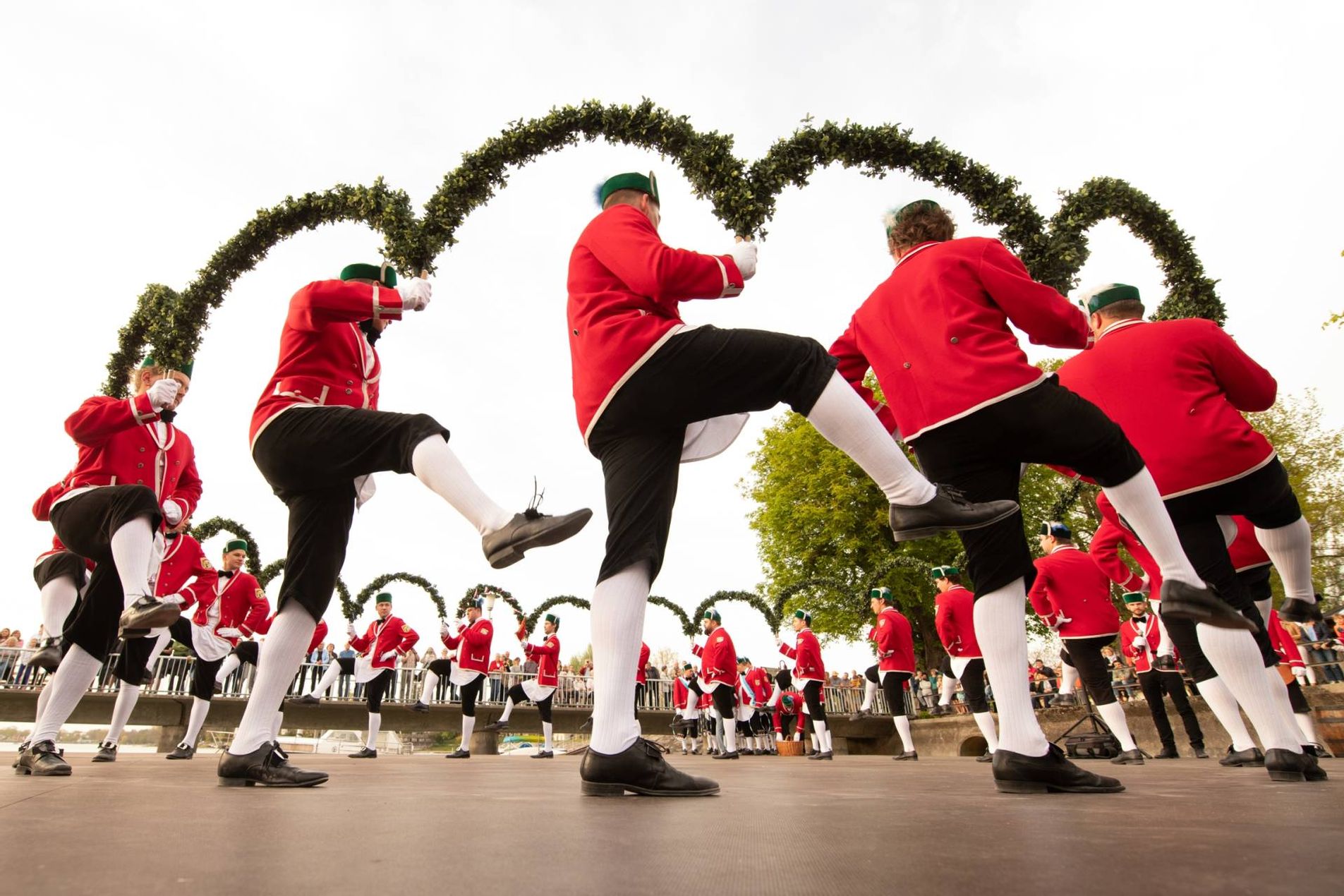 Die Schäffler tanzen im Kreis mit Kränzen aus Buchs