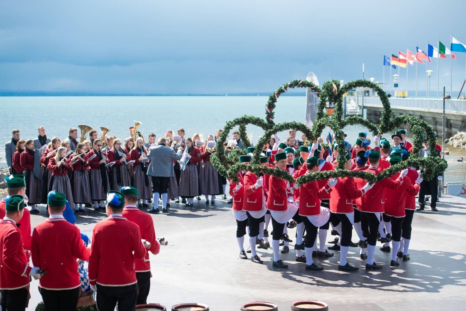 Szene aus dem Schäfflertanz, man sieht den Musikverein Nonnenhorn und die Schäffler beim Bilden einer Figur (kleiner Kreis mit Kränzen)