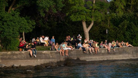 Musik und Wein am See, Leute sitzen am Seeufer