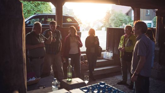 Weinprobe und Erklärung der historischen Weinpresse durch einen Winzer im Weintorkel