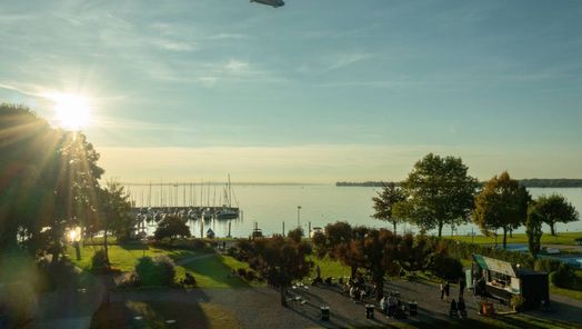 Blick von oben auf den Hafen, den See, den Uferpark mit Foodtruck