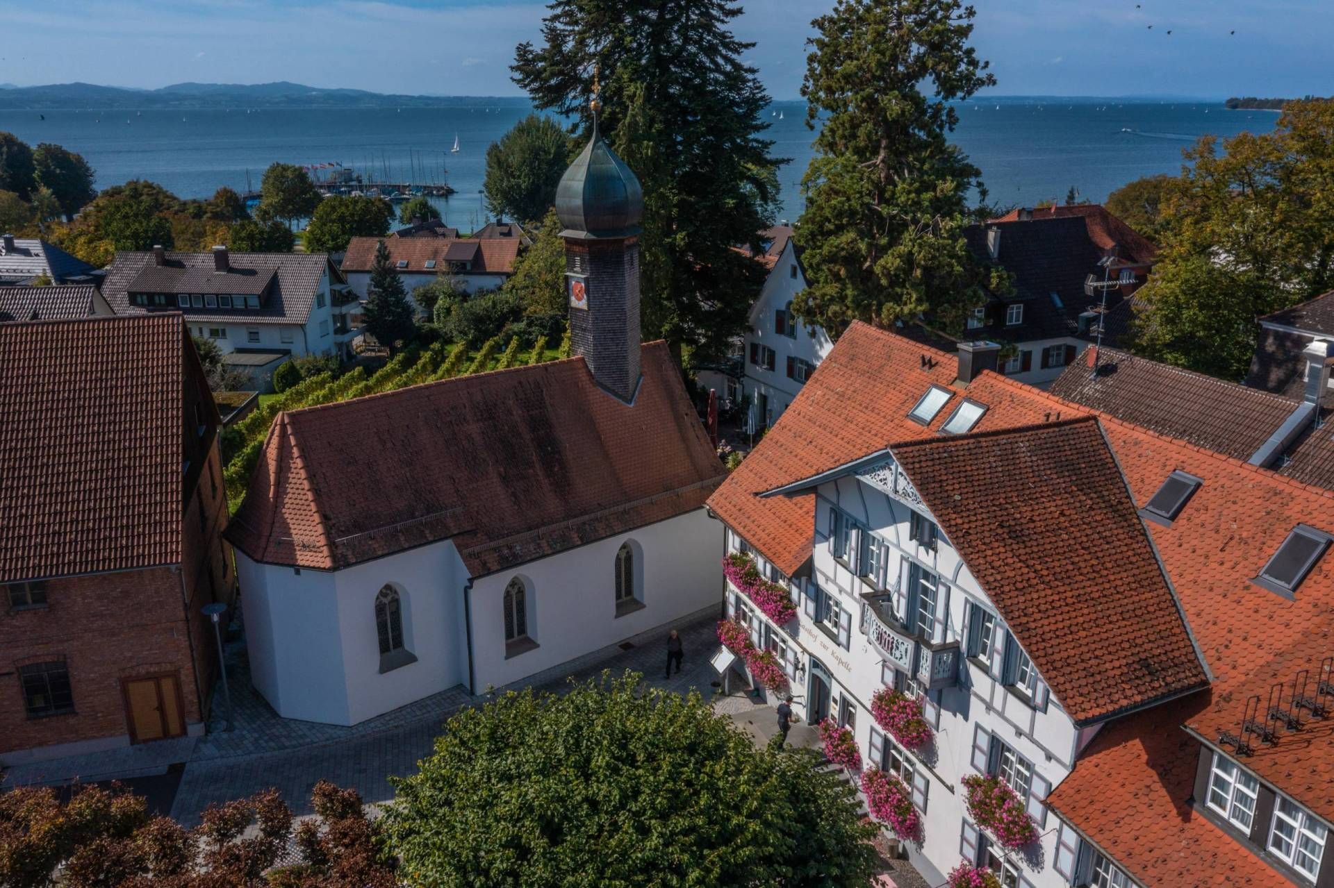 Blick von oben (Drohne) auf den See und den Kapellenplatz mit der St. Jakobus Kapelle und dem Gasthof zur Kapelle
