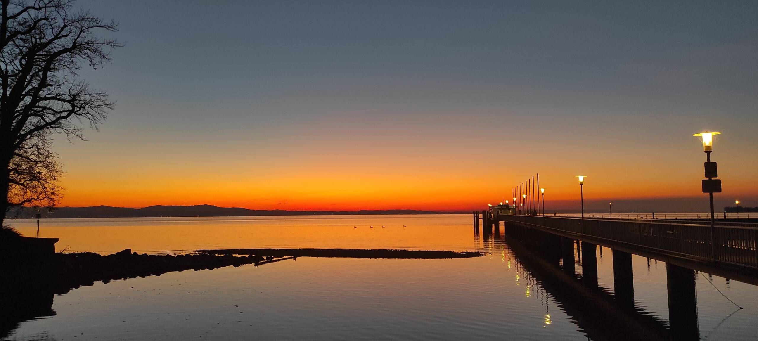 Der Landesteg in rotem Licht nach dem Sonnenuntergang