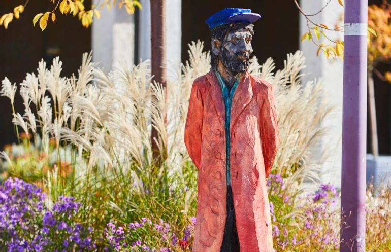 Holzfigur von Clemens Heinl auf dem Kirchplatz, sie stellt einen Schiffsanbinder von ehemals dar