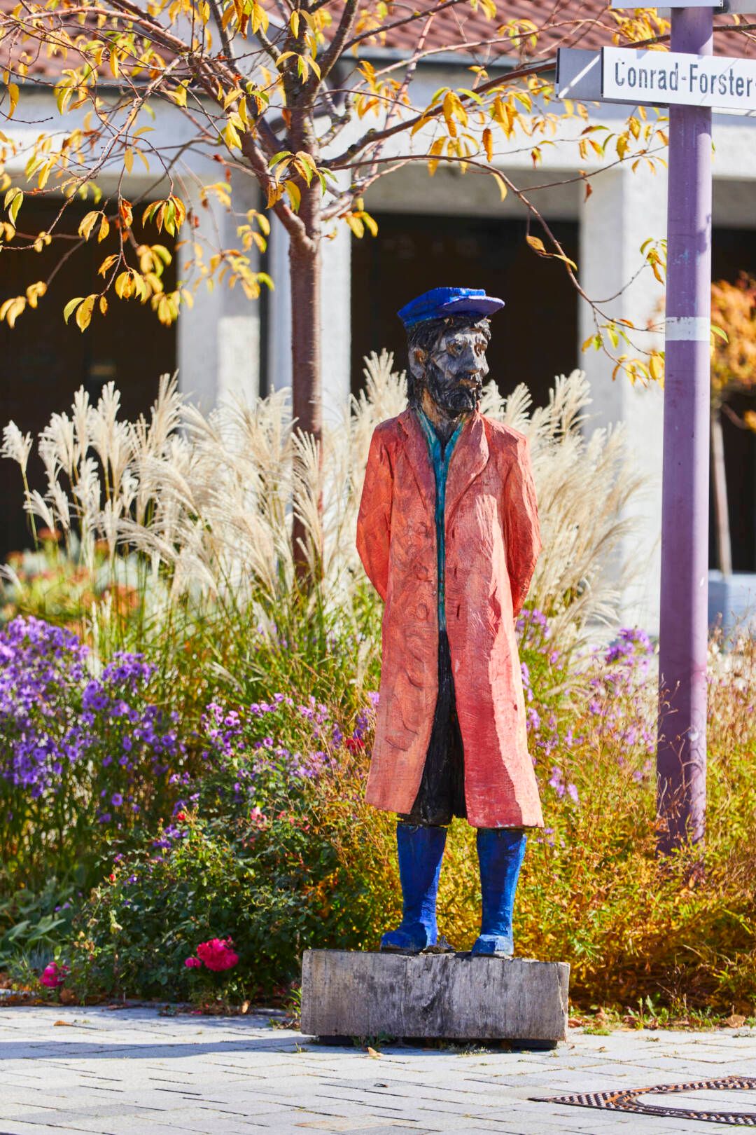 Holzfigur von Clemens Heinl auf dem Kirchplatz, sie stellt einen Schiffsanbinder von ehemals dar