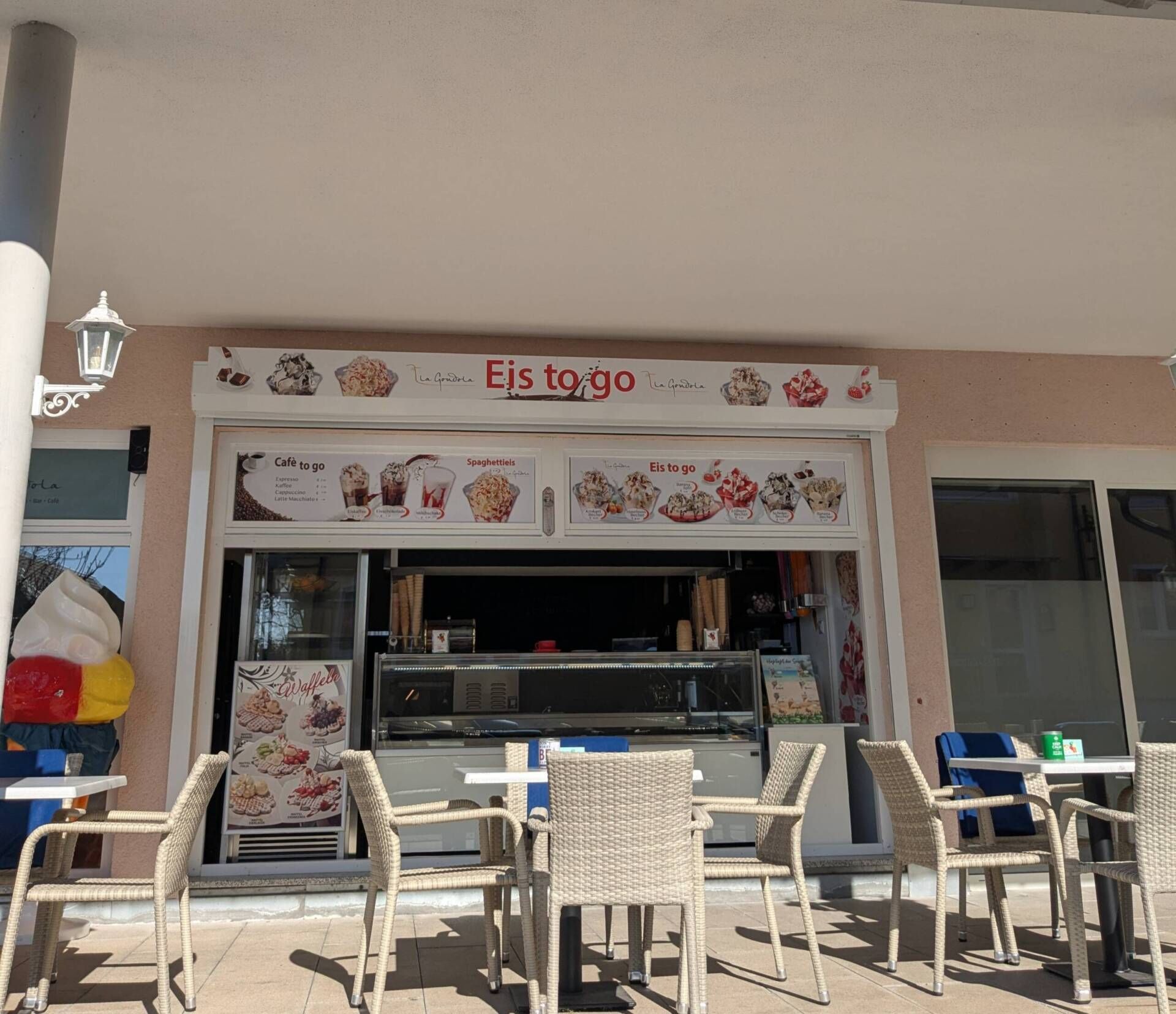 Eiscafe: Eistheke mit Stühlen und Tischen davor