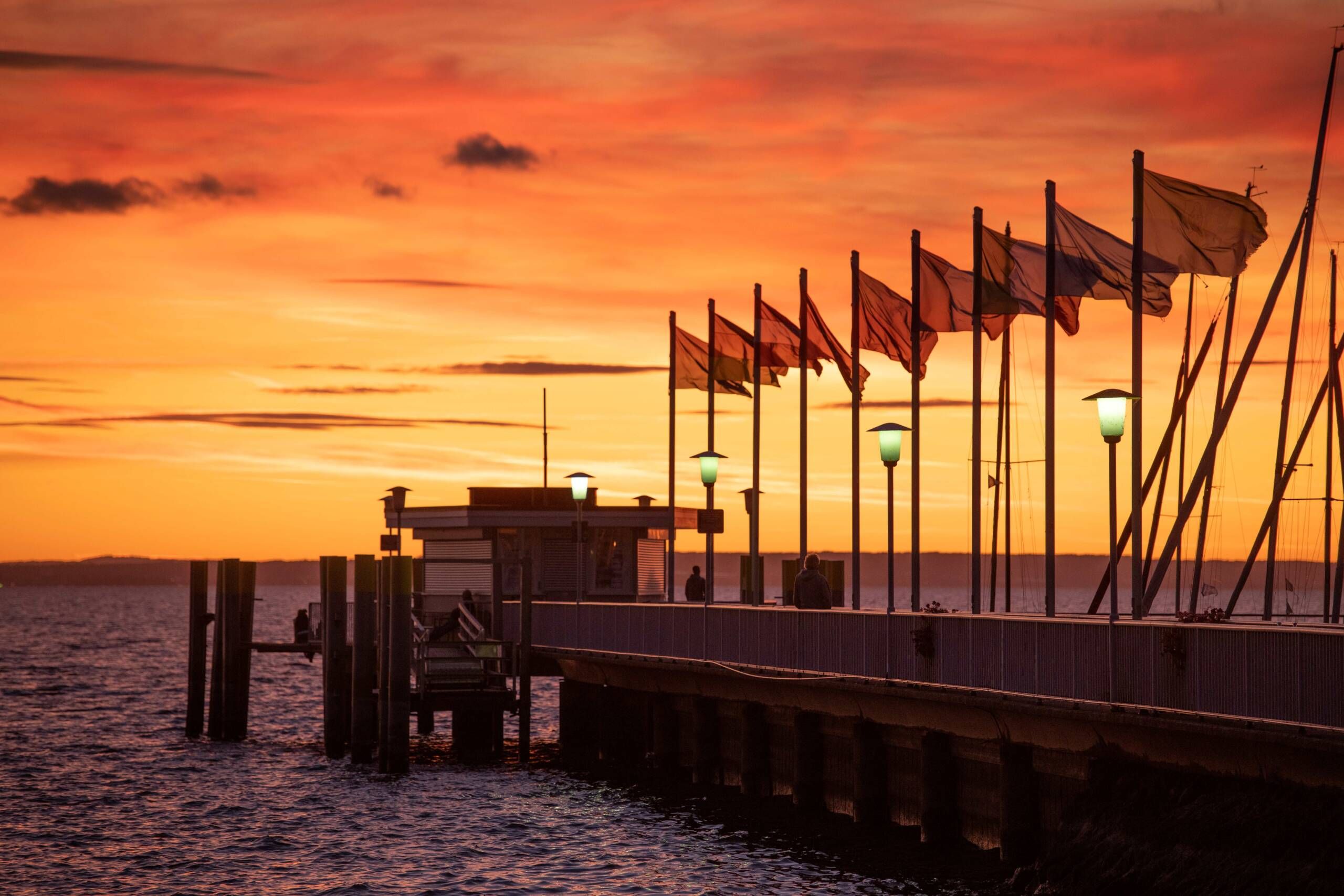 Landesteg mit Fahnen im Sonnenuntergang