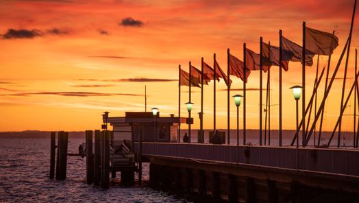 Landesteg mit Fahnen im Sonnenuntergang