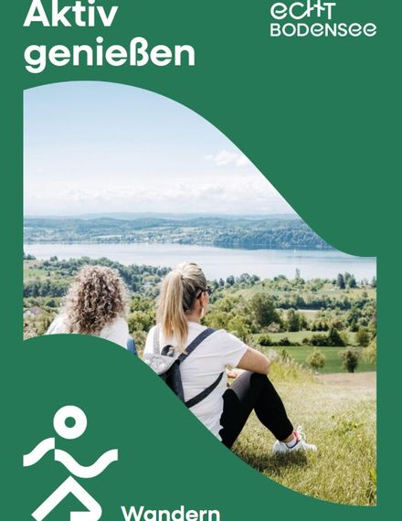 Zwei Frauen sitzen auf einer Wiese und genießen die Aussicht