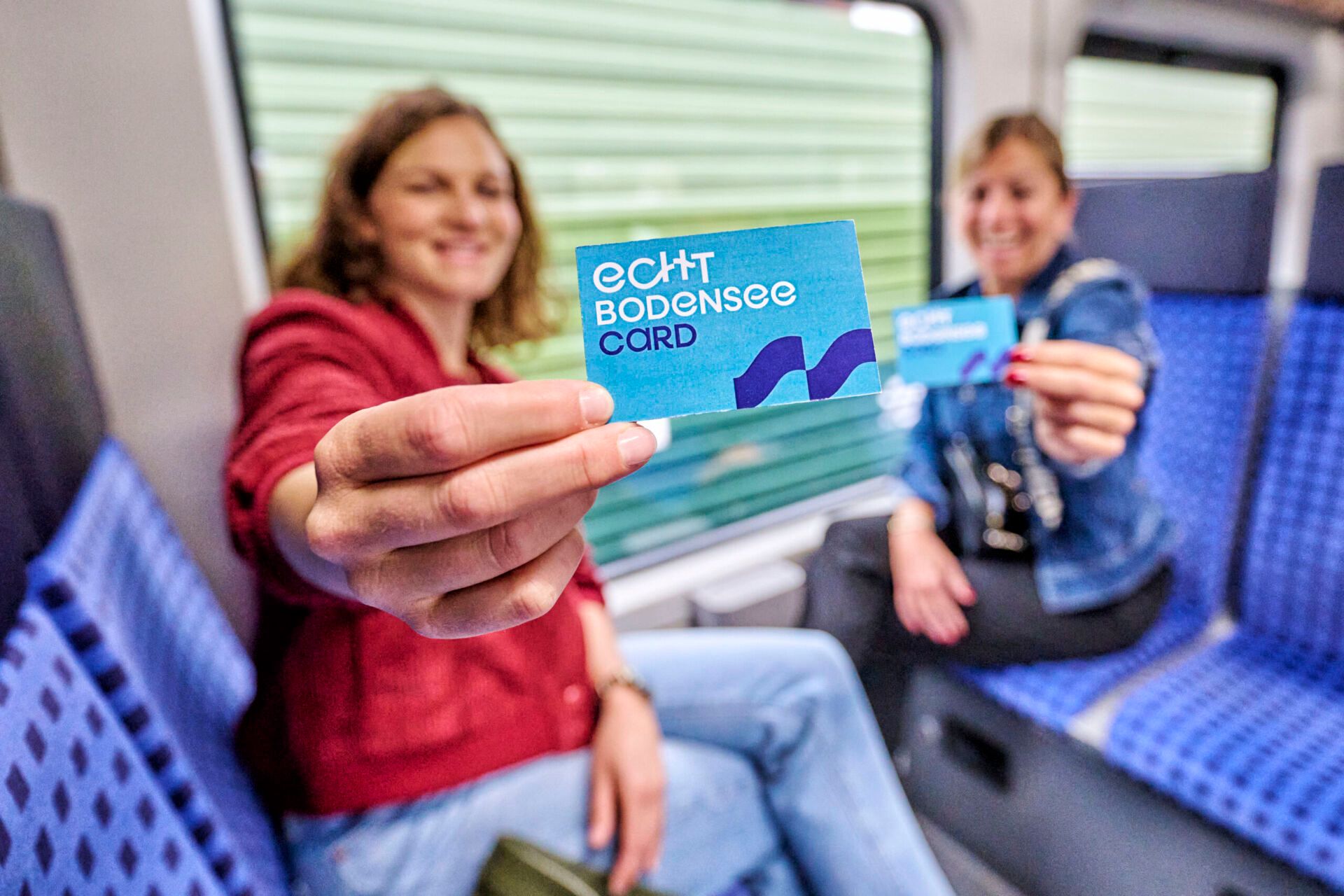 Zwei Frauen zeigen im Zug die Echt Bodensee Card vor.