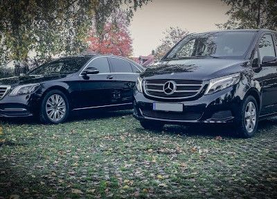 Zwei schwarze Mercedes stehen auf einem Parkplatz.