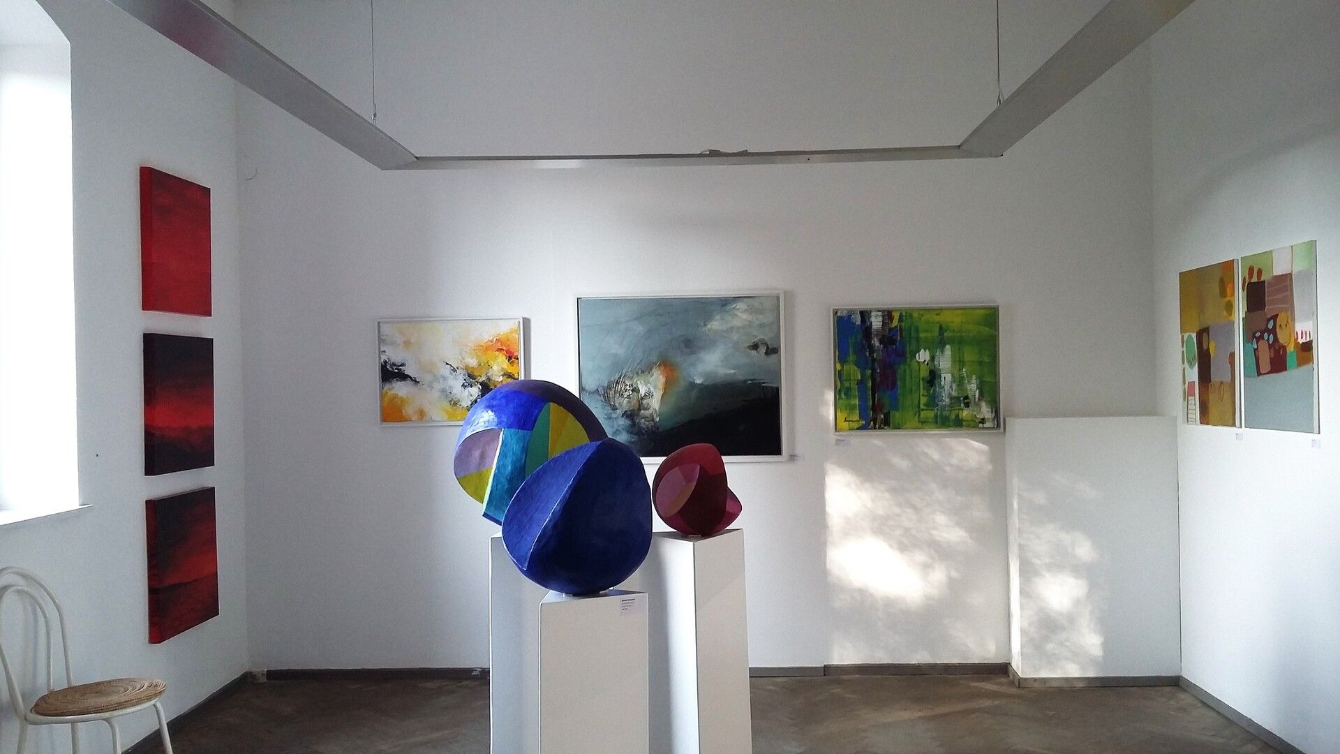 Kunst im KUBA Wasserburg. Das Bild zeigt den Ausstellungsraum mit verschiedenen ausgestellten Skulpturen und Bildern.