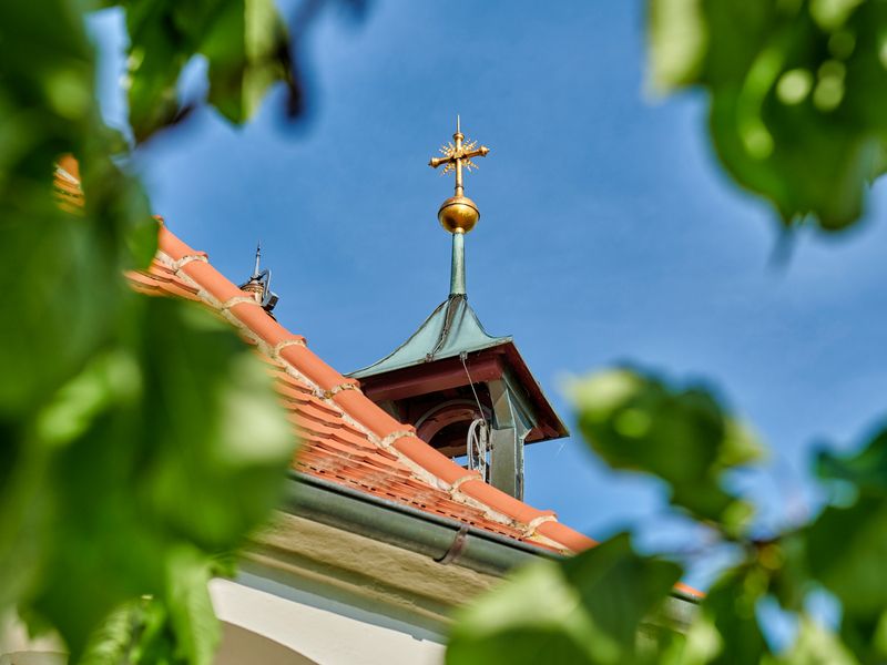 Kapellen- Turm der Antoniuskapelle in Selmnau mit goldenem Kreuz.