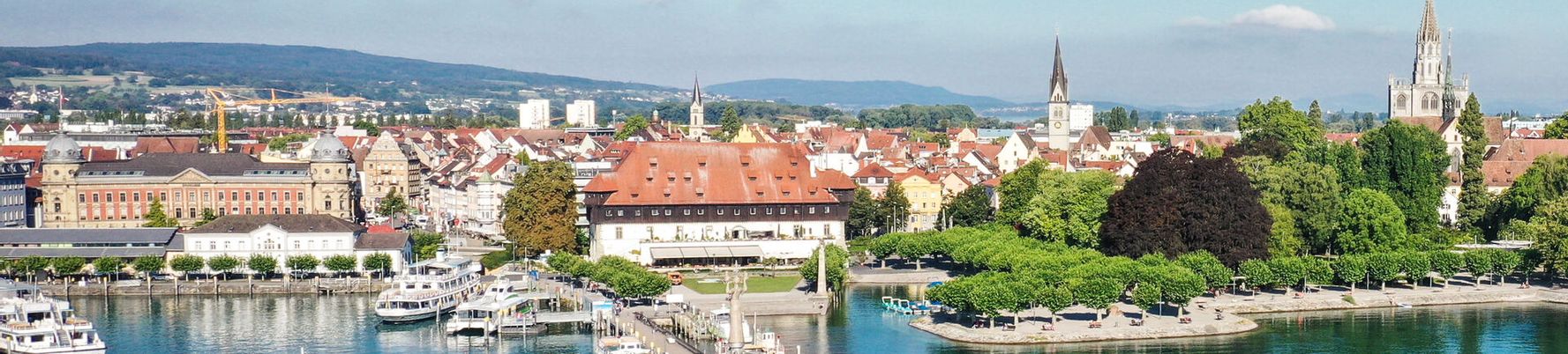 Luftaufnahme Hafeneinfahrt Konstanz. Im Vordergrund ist der See zu sehen und im Hintergrund Konstanz.