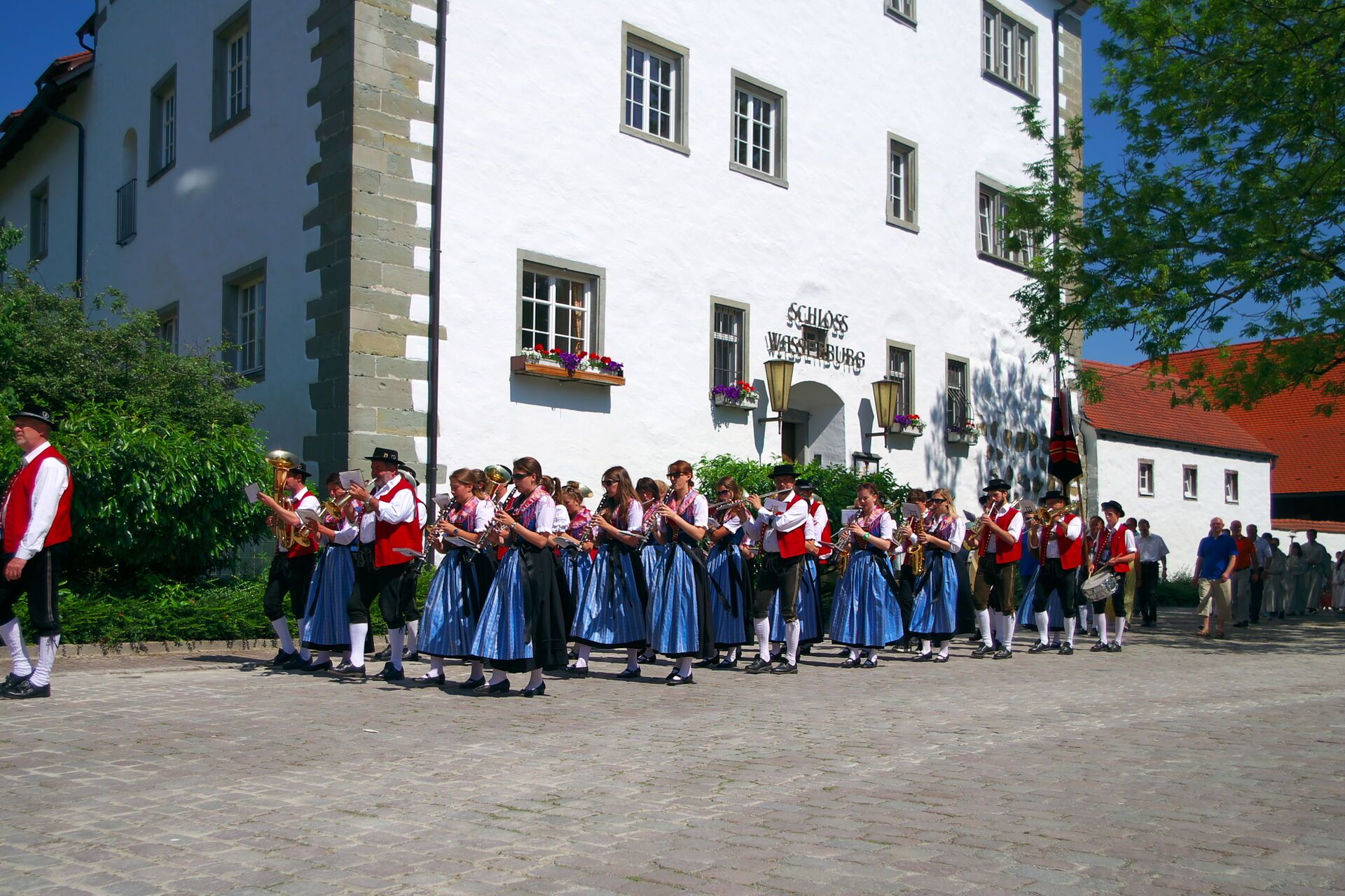 Christi Himmelfahrt in Wasserburg am Bodensee. Der Musikverein läuft am Schloss Wasserburg vorbei.