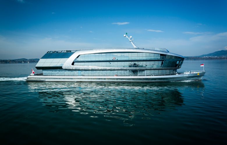 Das Schiff MS Sonnenkönigen fährt auf dem Bodensee. Im Hintergrund ist die Bergwelt zu sehen.
