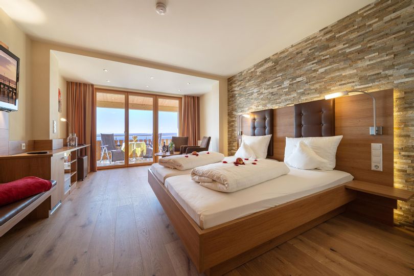 Zimmerinnenansicht einer Ferienwohnung. Schlafzimmer mit Doppelbett und einem Balkon.