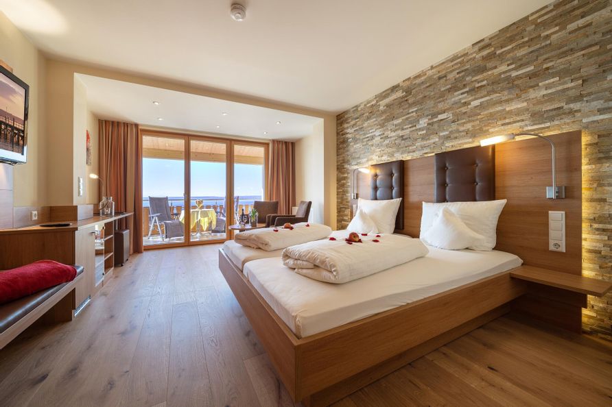 Zimmerinnenansicht einer Ferienwohnung. Schlafzimmer mit Doppelbett und einem Balkon.
