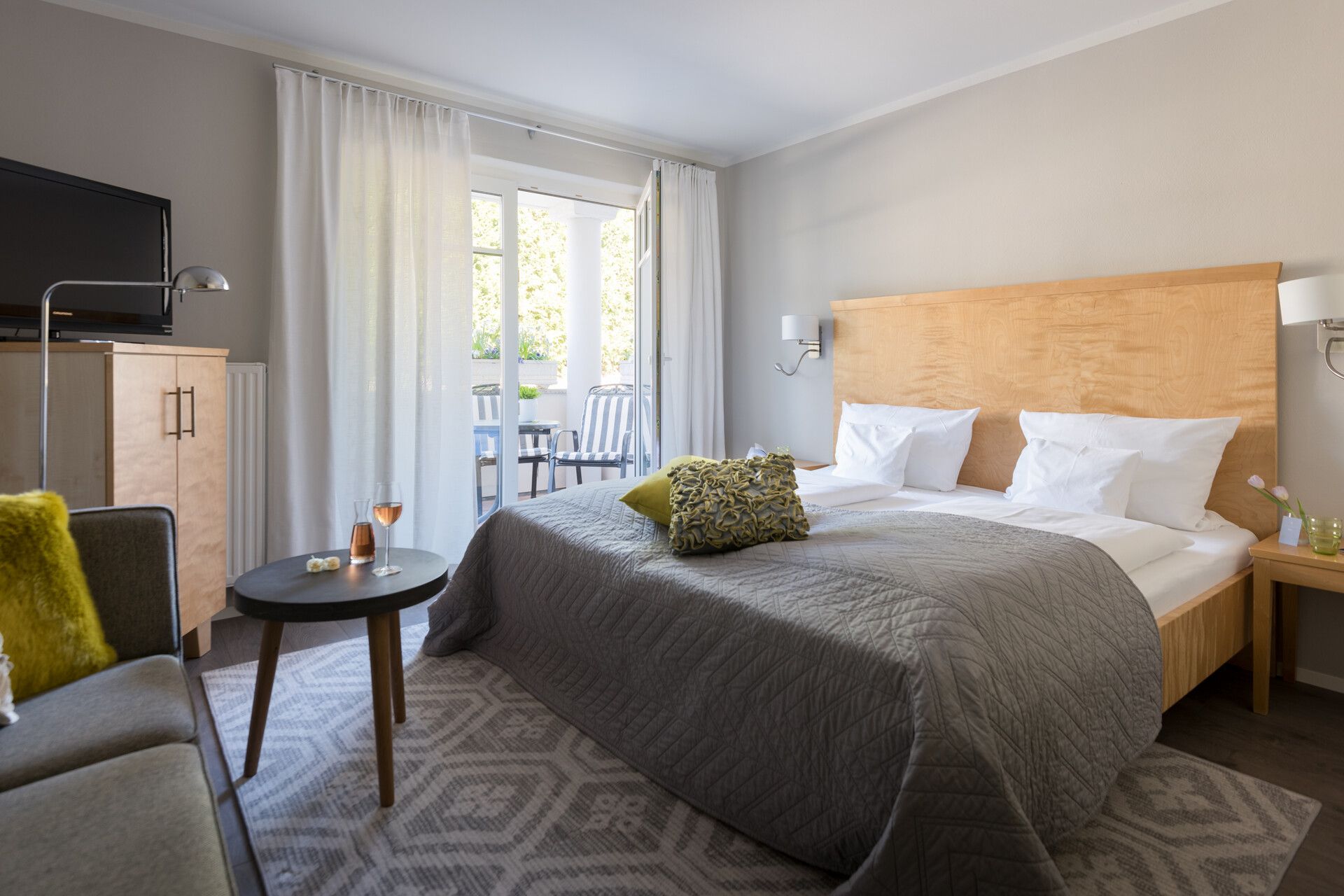 Zimmerinnenansicht von einem Hotel Schlafzimmer mit Doppelbett und einem Balkon.