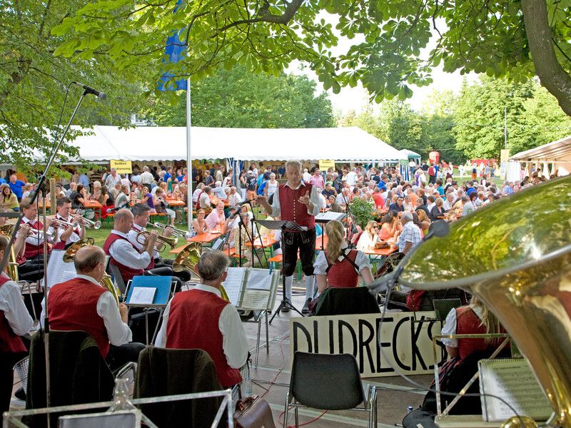 Uferfest des Musikvereins Wasserburg auf der Halbinsel. Eine Musikkapelle spielt vor mehreren Leuten.