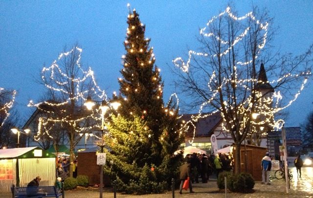 Adventsmarkt in Wasserburg auf dem Lindenplatz. Die Bäume am Lindenplatz sowie der Weihnachtsbaum sind beleuchtet.