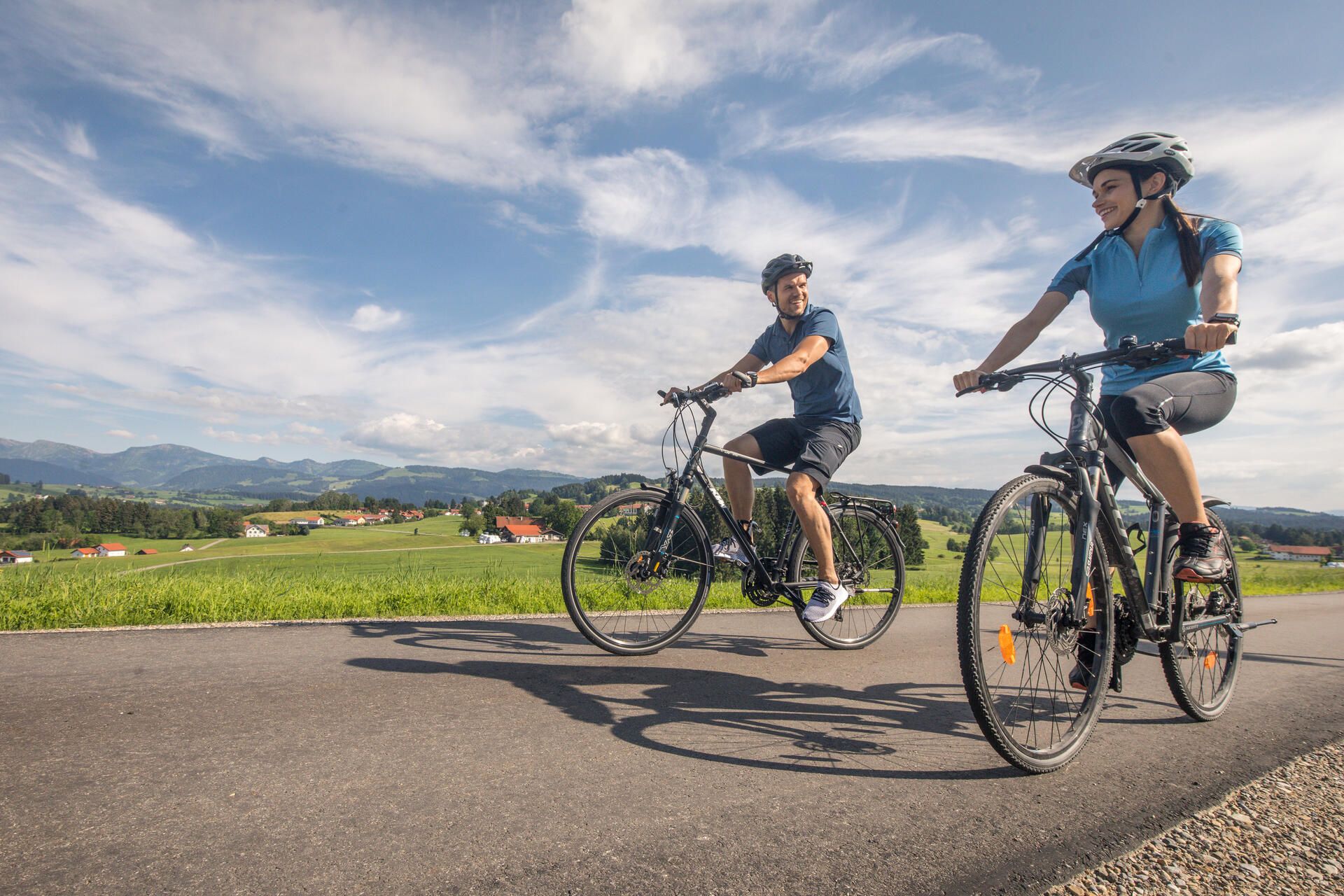 Eine Frau und ein Mann fahren auf dem Radweg von der Radtour Lindauer Bodensee.