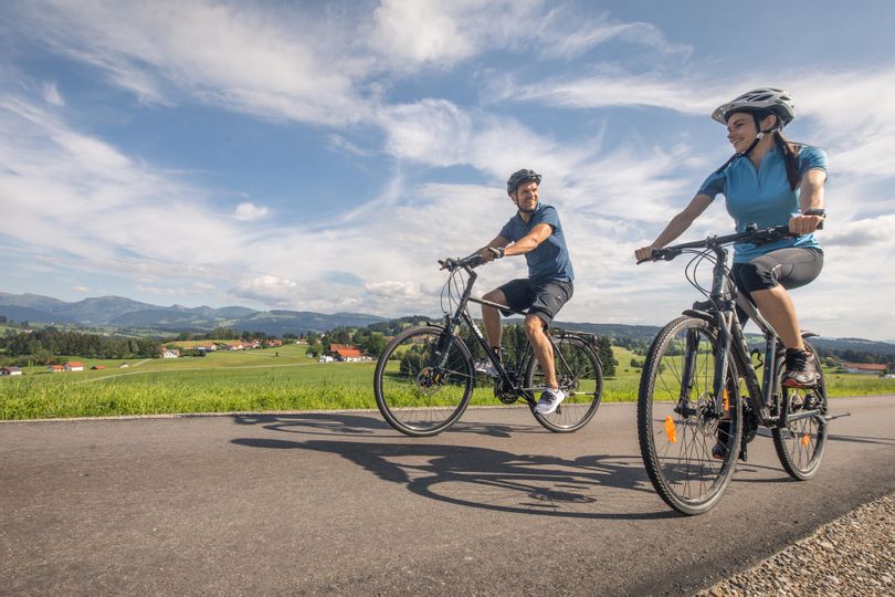Eine Frau und ein Mann fahren auf dem Radweg von der Radtour Lindauer Bodensee.