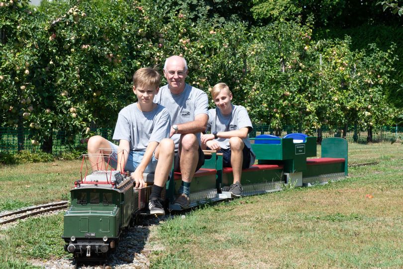 Ehrles Garteneisenbahn. Drei Personen auf der Garteneisenbahn.