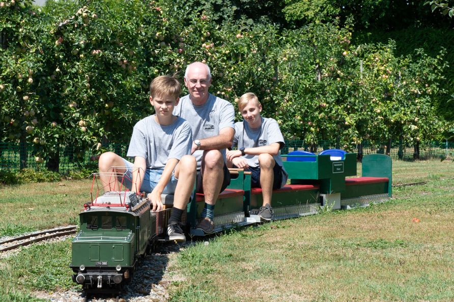 Ehrles Garteneisenbahn. Drei Personen auf der Garteneisenbahn.
