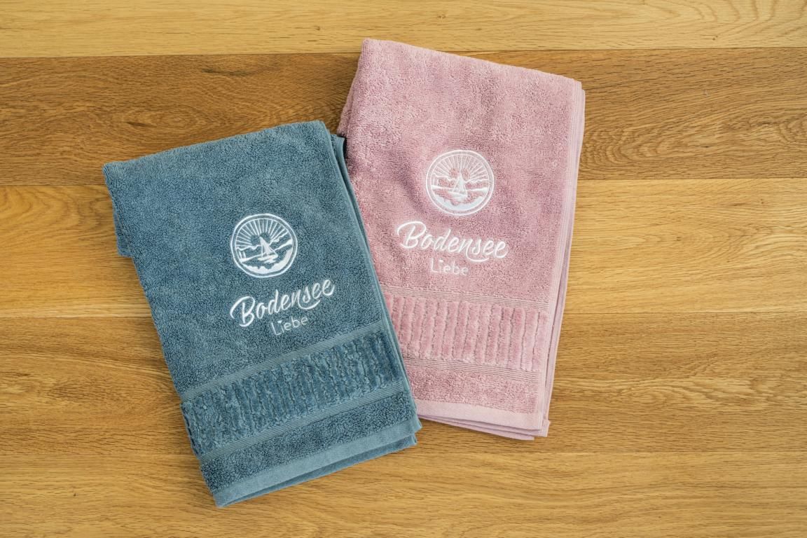 Bodenseeliebe Duschtuch und Badehandtuch in grau und rosa.