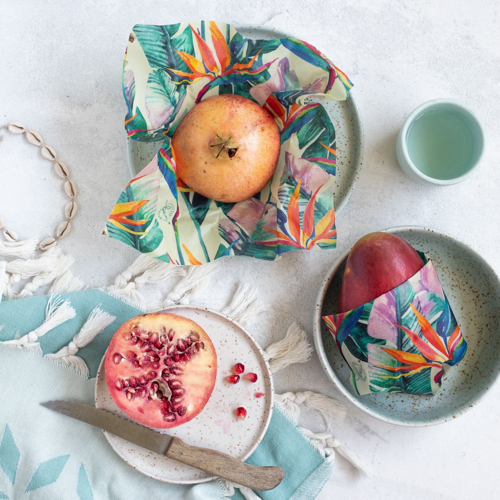 Little Bee Fresh, 100% Bio-Bienenwachstücher auf einem Tisch mit einem Granatapfel