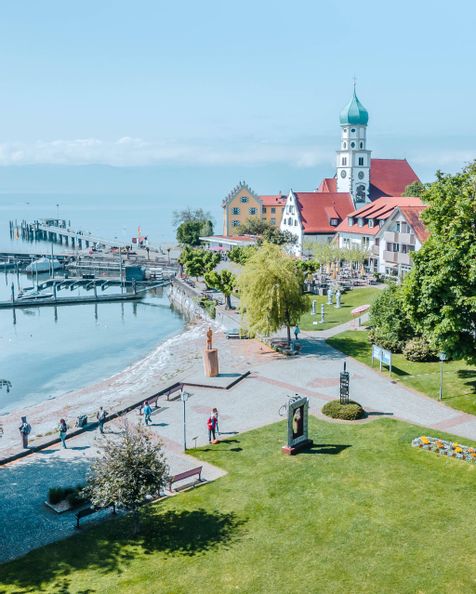 Luftaufnahme Halbinsel Wasserburg mit See und Bergwelt im Hintergrund