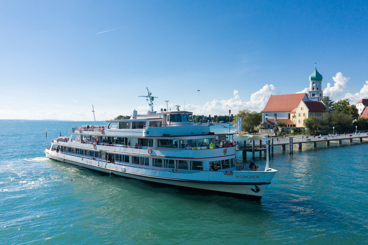 Schiff legt an der Schiffsanlegestelle in Wasserburg an. Im Hintergrund die Halbinsel