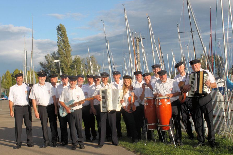 Gruppenbild der Bodensee-Shantymen Überlingen mit Segelhafen im Hintergrund.
