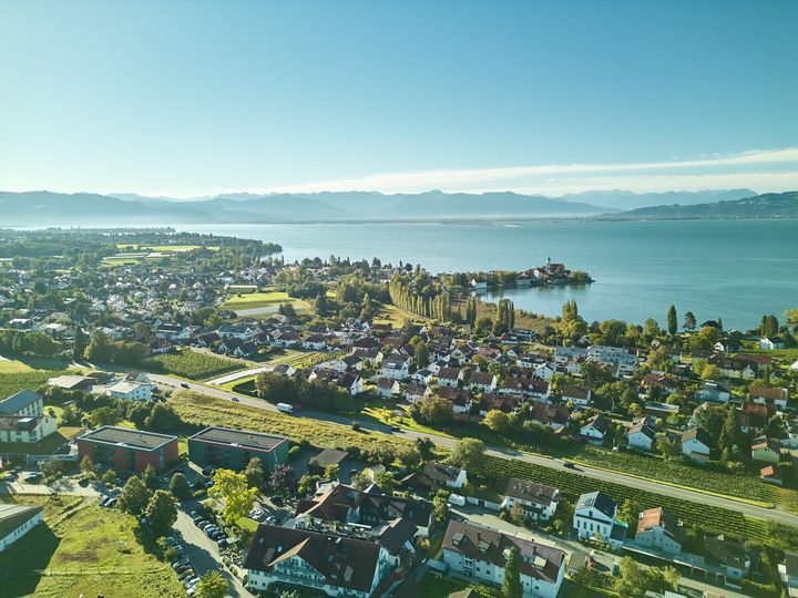 Wasserburger Luftaufnahme mit der Halbinsel in Wasserburg und Umgebung. Im Hintergrund der Bodensee sowie die Berge