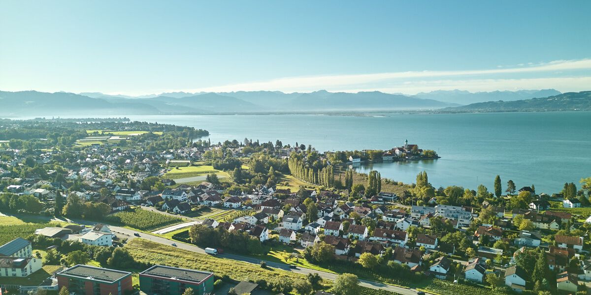 Wasserburger Luftaufnahme mit der Halbinsel in Wasserburg und Umgebung. Im Hintergrund der Bodensee sowie die Berge