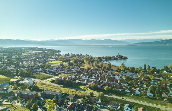 Wasserburger Luftaufnahme mit der Halbinsel in Wasserburg und Umgebung. Im Hintergrund der Bodensee sowie die Berge