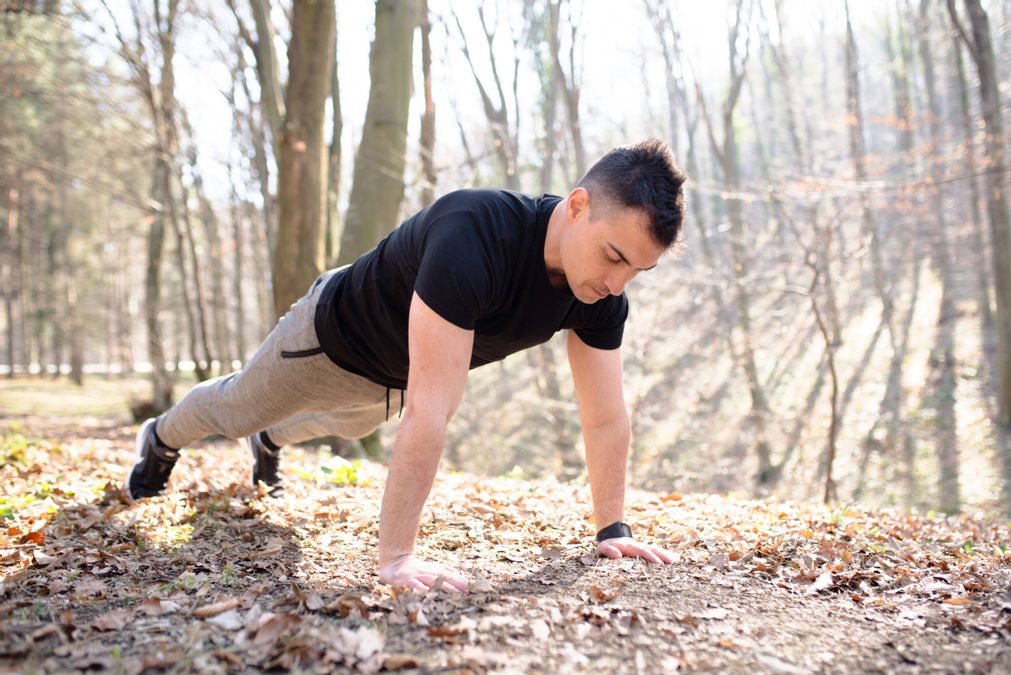 Ein Mann der in der Natur Liegestützen macht